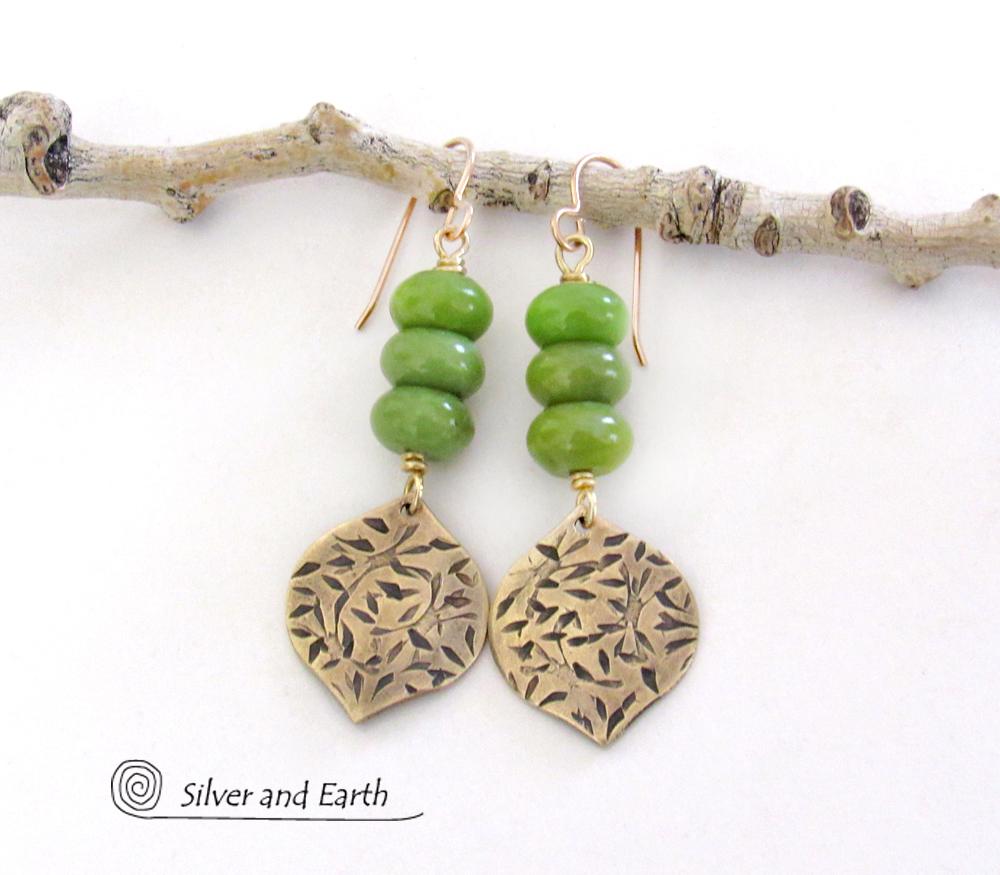  These handcrafted earrings feature gold brass dangles with a hand stamped texture accented with a stack of green serpentine gemstones. They have an earthy chic, modern style that coordinates well with all wardrobe types.These artisan-made earrings are perfect for adding a touch of earthy modern style to any outfit.  
