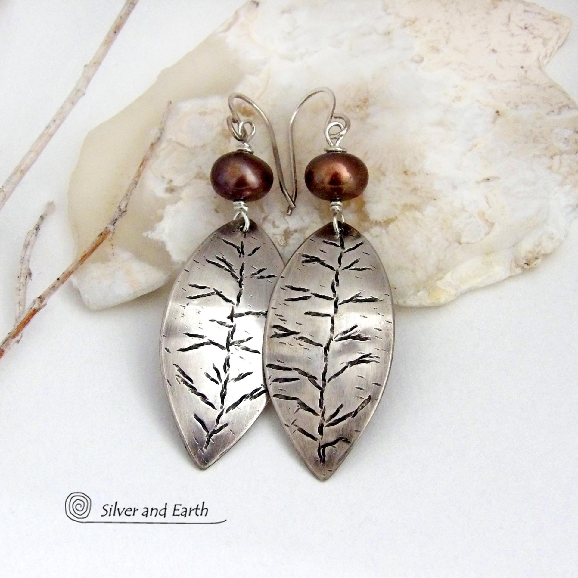 These handcrafted sterling silver leaf earrings have a delicate hand stamped texture and are accented with bronze freshwater pearls. They have a modern, earthy elegance that coordinates beautifully with all wardrobe styles. They'll make a great gift for a nature lover. Handcrafted exclusively in the USA by Silver and Earth Jewelry, a New Mexico True Certified business.