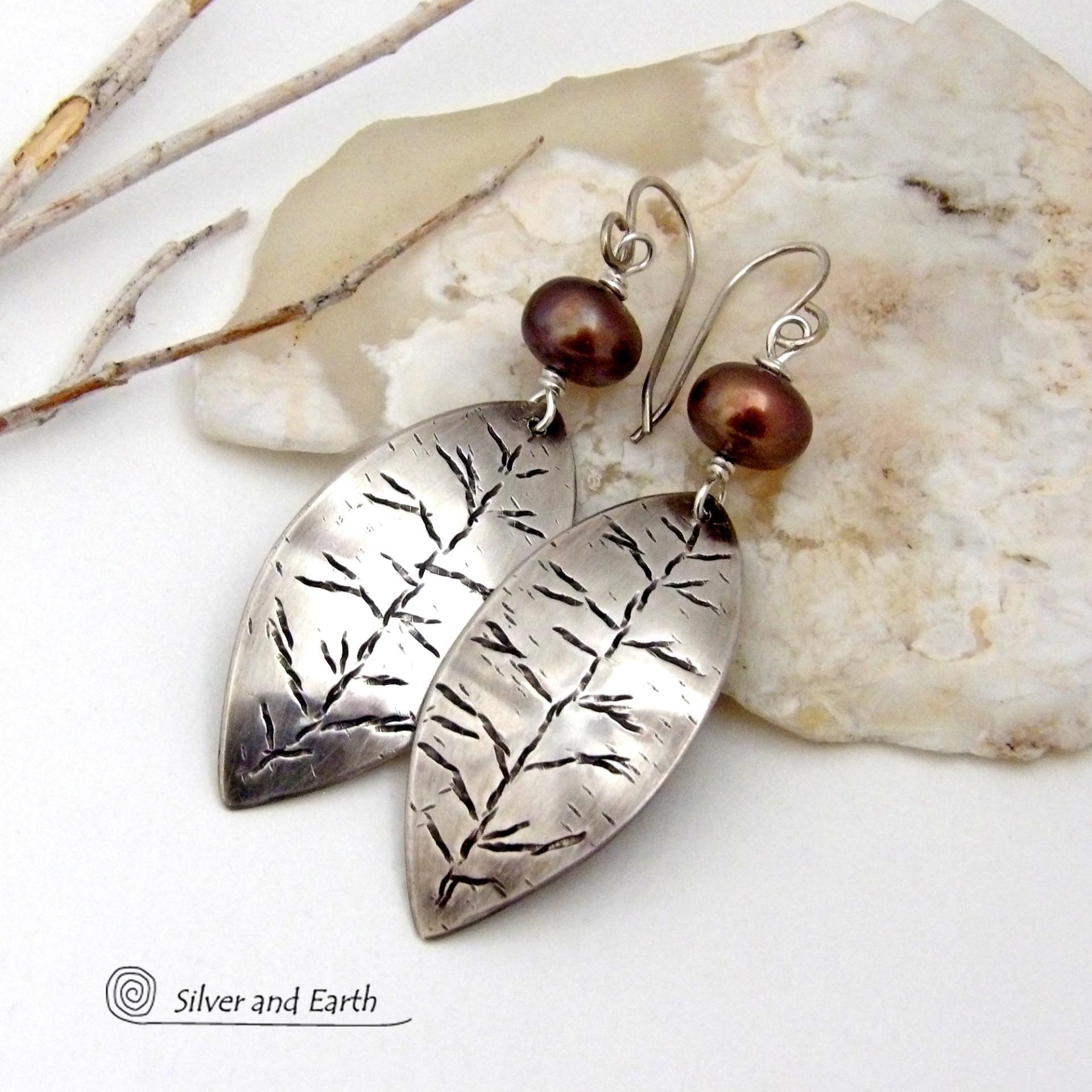 These handcrafted sterling silver leaf earrings have a delicate hand stamped texture and are accented with bronze freshwater pearls. They have a modern, earthy elegance that coordinates beautifully with all wardrobe styles. They'll make a great gift for a nature lover. Handcrafted exclusively in the USA by Silver and Earth Jewelry, a New Mexico True Certified business.