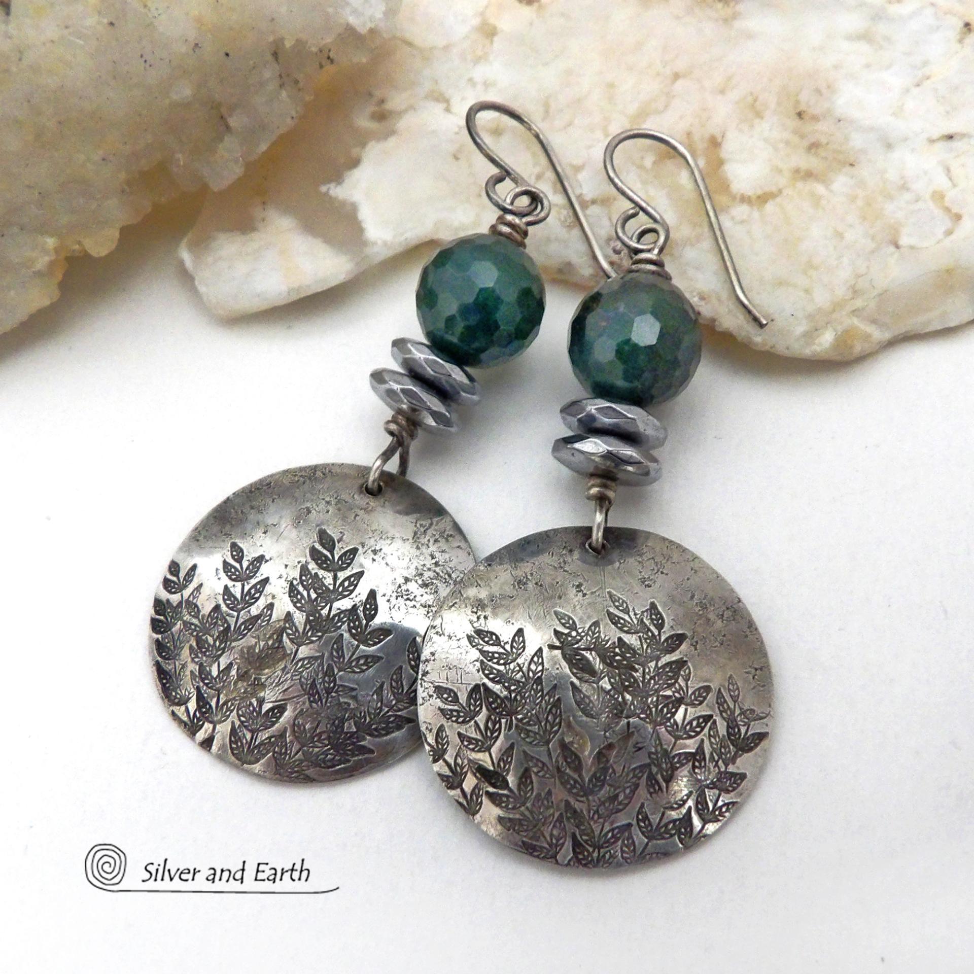 These handcrafted sterling silver earrings feature a hand stamped leaf design and are accented with dark green moss agate gemstones. The stones have a micro-faceted finish which gives off a natural sparkle and shine and are accented them with faceted silver hematite gemstones which also give off a natural sparkle. These earrings have a modern chic and elegant style that coordinates beautifully with all wardrobe types - dressed up or down. Handmade in the USA by Silver and Earth Jewelry. 