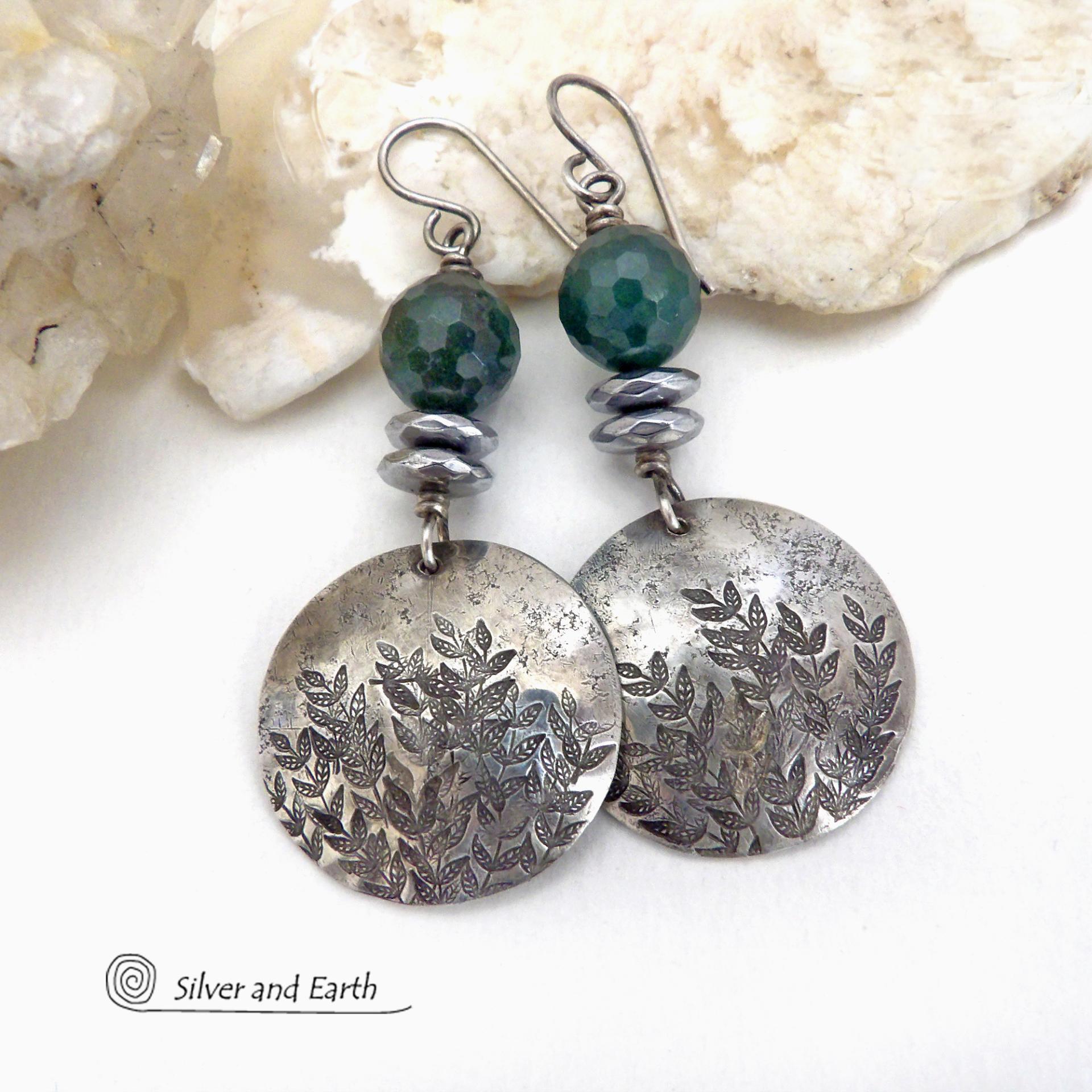 These handcrafted sterling silver earrings feature a hand stamped leaf design and are accented with dark green moss agate gemstones. The stones have a micro-faceted finish which gives off a natural sparkle and shine and are accented them with faceted silver hematite gemstones which also give off a natural sparkle. These earrings have a modern chic and elegant style that coordinates beautifully with all wardrobe types - dressed up or down. Handmade in the USA by Silver and Earth Jewelry. 