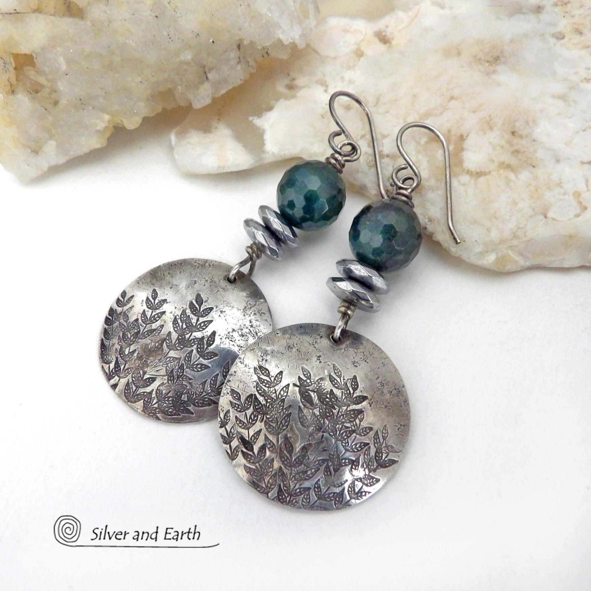 These handcrafted sterling silver earrings feature a hand stamped leaf design and are accented with dark green moss agate gemstones. The stones have a micro-faceted finish which gives off a natural sparkle and shine and are accented them with faceted silver hematite gemstones which also give off a natural sparkle. These earrings have a modern chic and elegant style that coordinates beautifully with all wardrobe types - dressed up or down. Handmade in the USA by Silver and Earth Jewelry. 