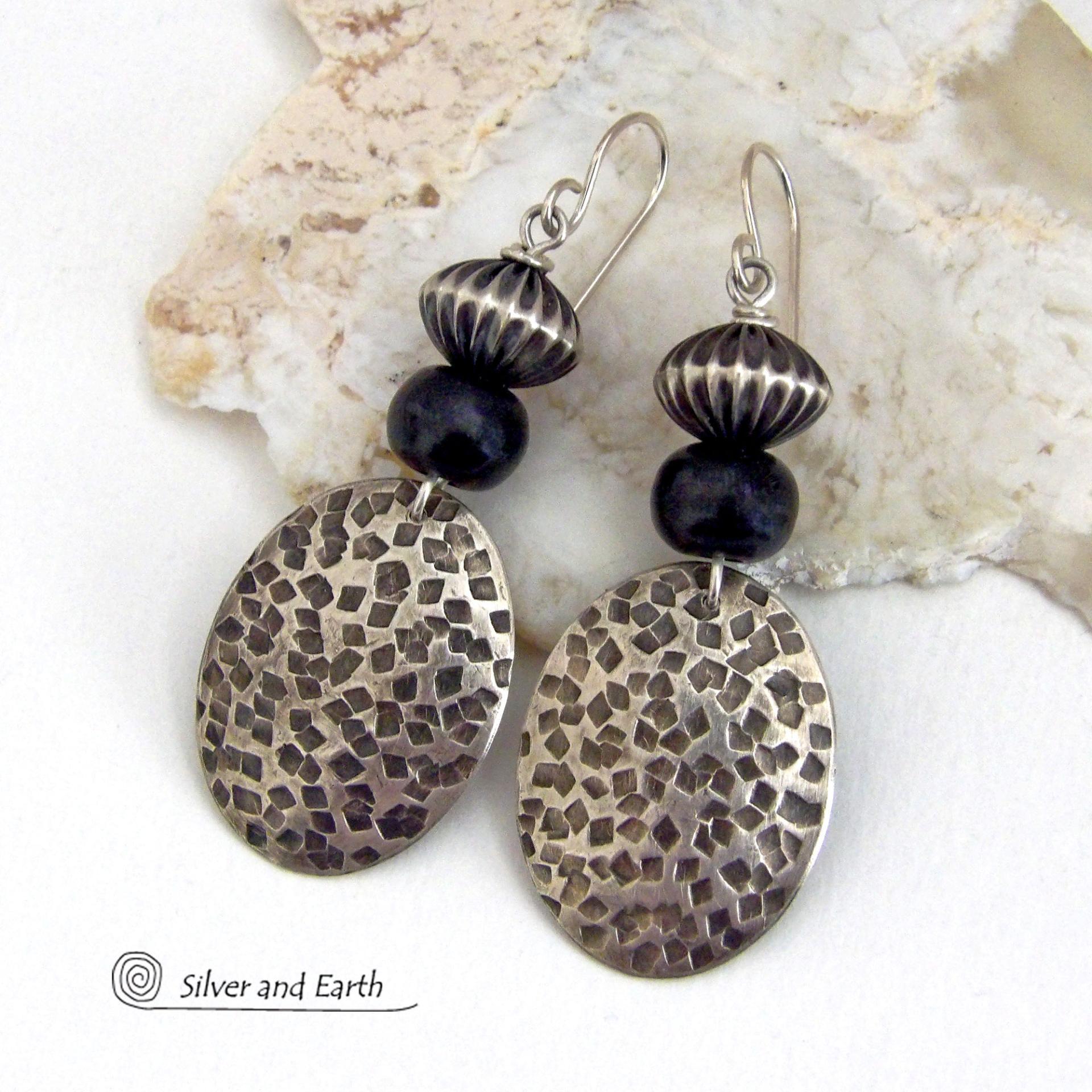 These sterling silver earrings have an earthy, southwestern tribal style. They feature hand textured sterling silver dangles accented with black buffalo horn and Native Navajo pearl style sterling silver beads with a rich, corrugated texture. Unique and striking, they'll make a bold statement. Handmade in the USA by Silver and Earth Jewelry. 