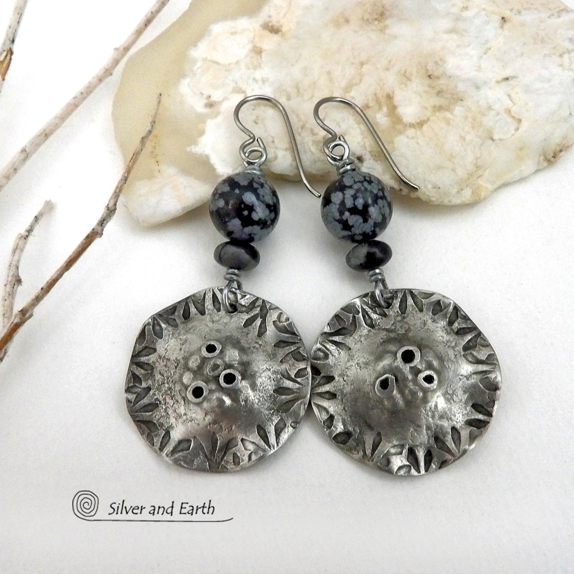 Handcrafted earrings with a modern bold edgy vibe. They feature rustic hammered and hand stamped silver tone pewter dangles accented with natural snowflake obsidian gemstones. The stones have a natural pattern in hues of black and soft gray. This stone is a natural volcanic glass which contains the mineral cristobalite - which creates the "snowflake" type patterns. Bold and striking - they're sure to make a statement. Earrings l