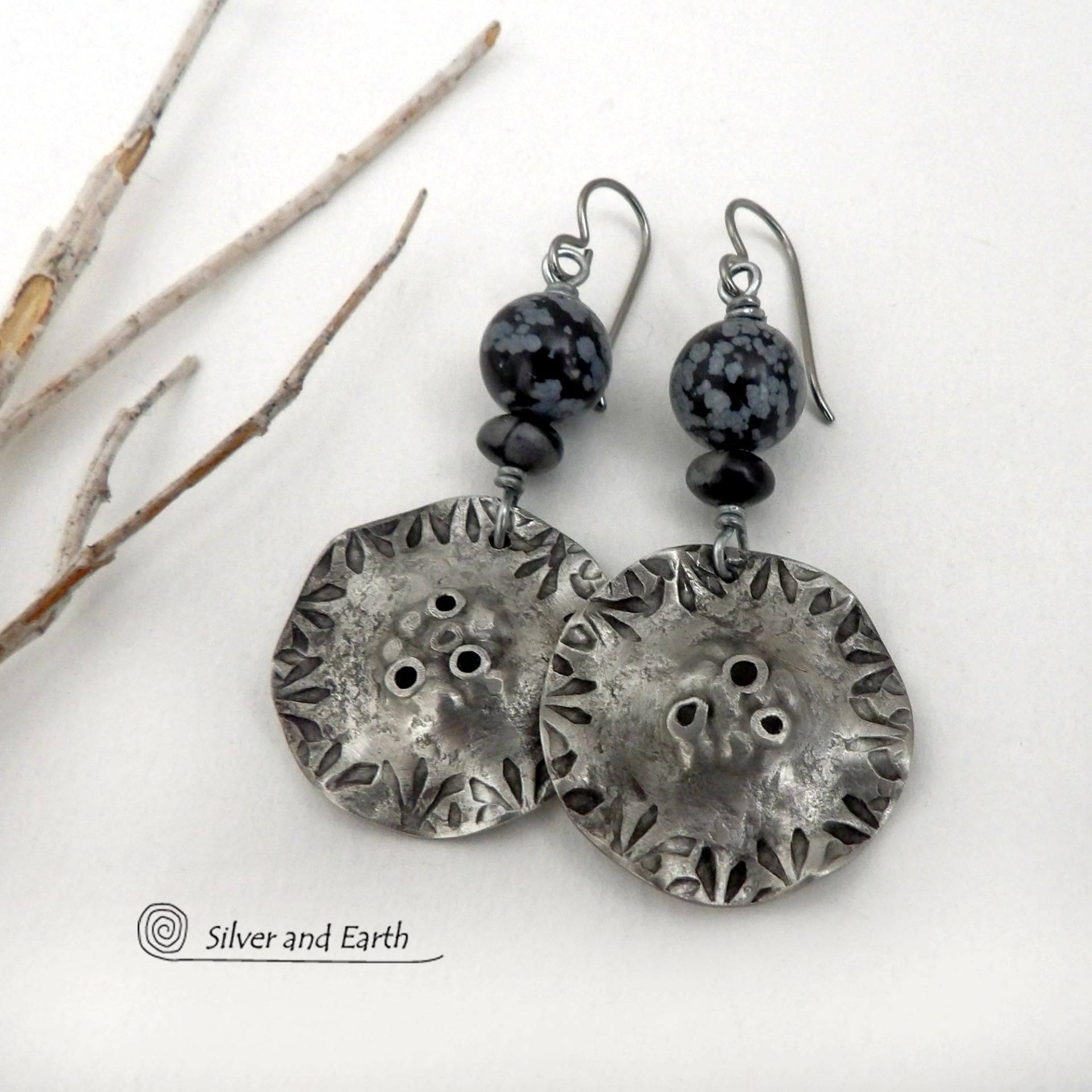 Handcrafted earrings with a modern bold edgy vibe. They feature rustic hammered and hand stamped silver tone pewter dangles accented with natural snowflake obsidian gemstones. The stones have a natural pattern in hues of black and soft gray. This stone is a natural volcanic glass which contains the mineral cristobalite - which creates the "snowflake" type patterns. Bold and striking - they're sure to make a statement. Perfect for women that love natural stones and unique artisan handmade jewelry. 