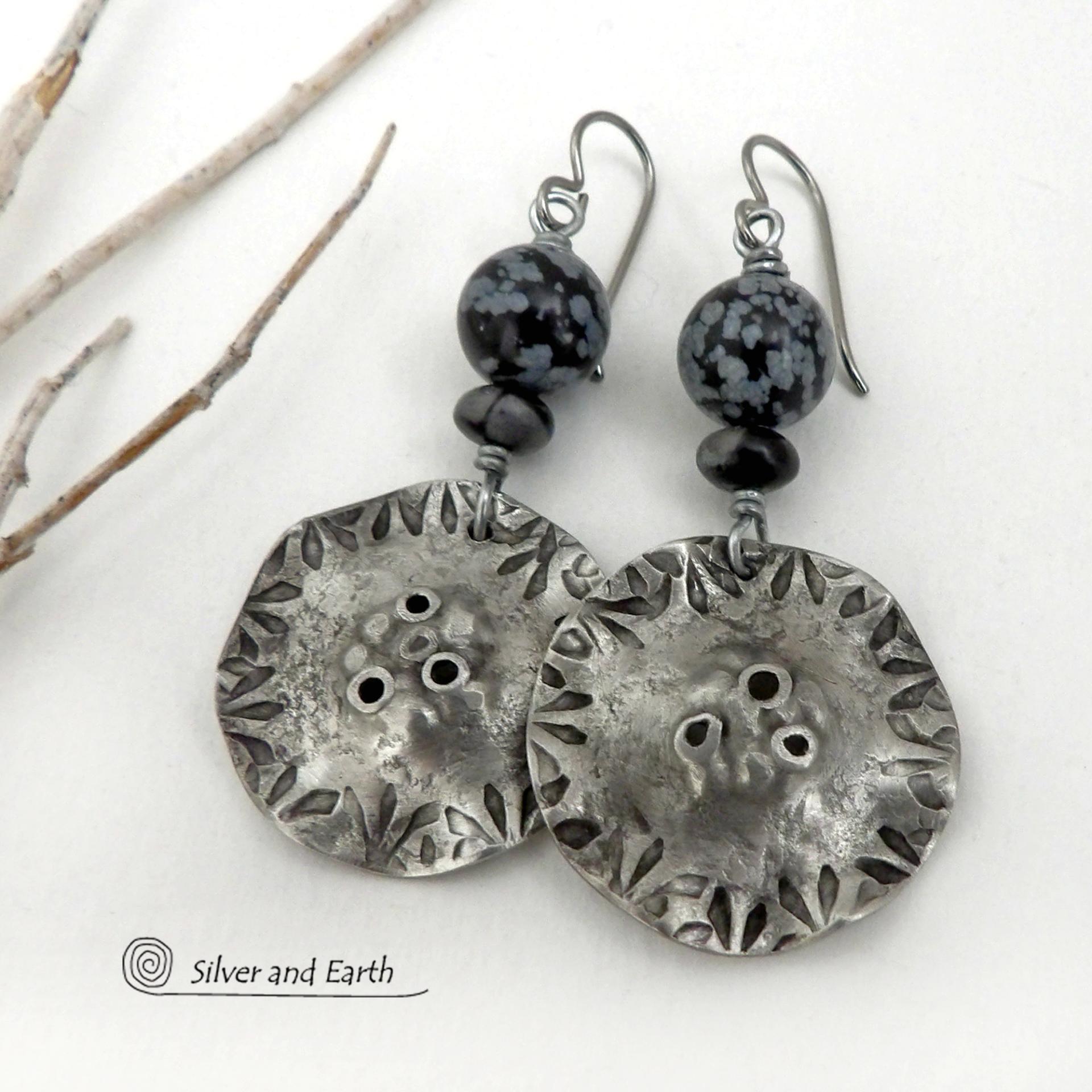 Handcrafted earrings with a modern bold edgy vibe. They feature rustic hammered and hand stamped silver tone pewter dangles accented with natural snowflake obsidian gemstones. The stones have a natural pattern in hues of black and soft gray. This stone is a natural volcanic glass which contains the mineral cristobalite - which creates the "snowflake" type patterns. Bold and striking - they're sure to make a statement. Earrings l