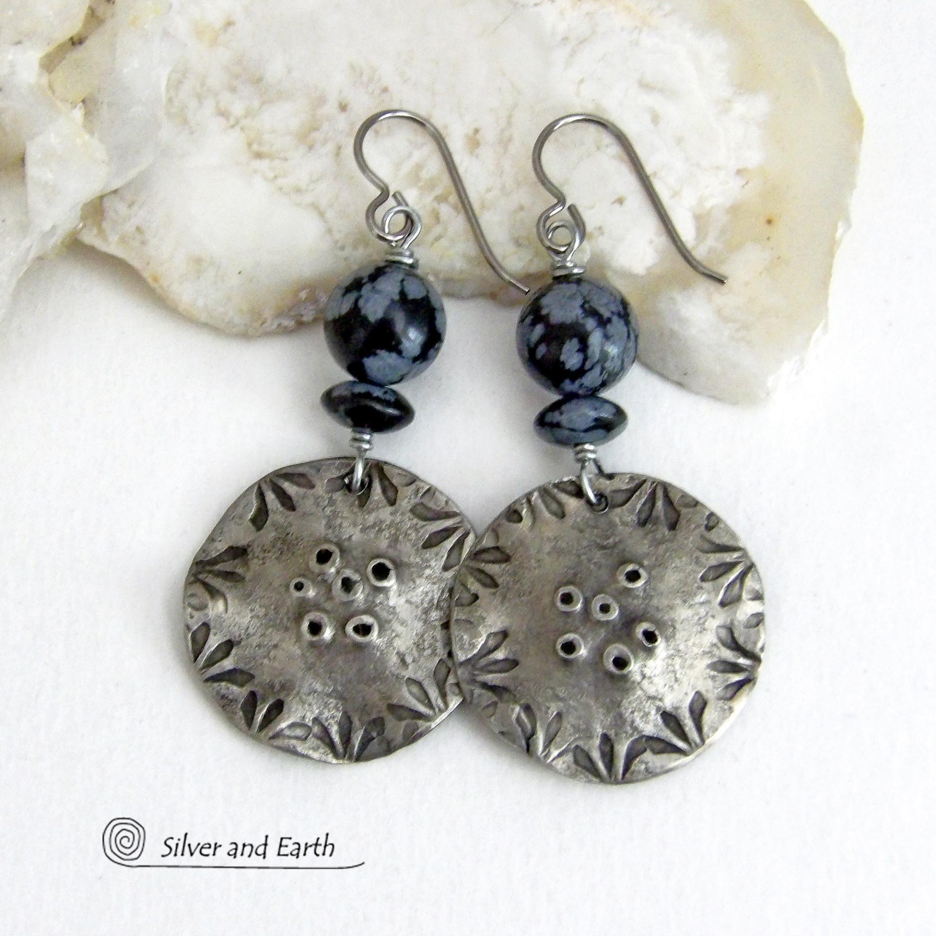 These handcrafted earrings have a modern bold edgy vibe. They feature rustic hammered and hand stamped silver tone pewter dangles accented with natural snowflake obsidian gemstones. The stones have a natural pattern in hues of black and soft gray. This stone is a natural volcanic glass which contains the mineral cristobalite - which creates the "snowflake" type patterns. Bold and striking - they're sure to make a statement. Perfect for women that love natural stones and unique artisan handmade jewelry. 
