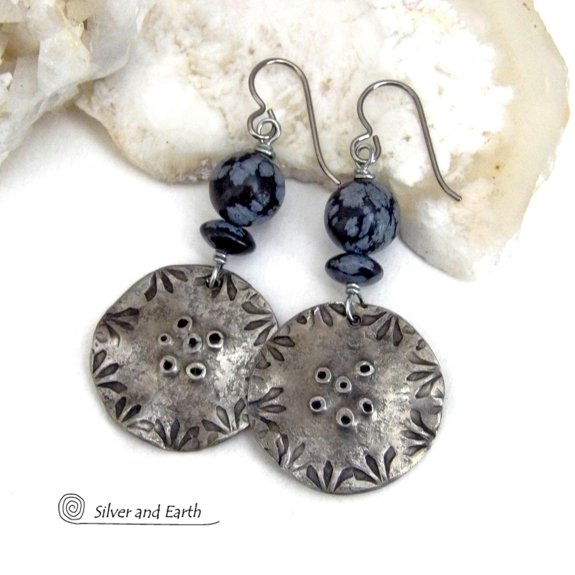 These handcrafted earrings have a modern bold edgy vibe. They feature rustic hammered and hand stamped silver tone pewter dangles accented with natural snowflake obsidian gemstones. The stones have a natural pattern in hues of black and soft gray. This stone is a natural volcanic glass which contains the mineral cristobalite - which creates the "snowflake" type patterns. Bold and striking - they're sure to make a statement. Perfect for women that love natural stones and unique artisan handmade jewelry. 