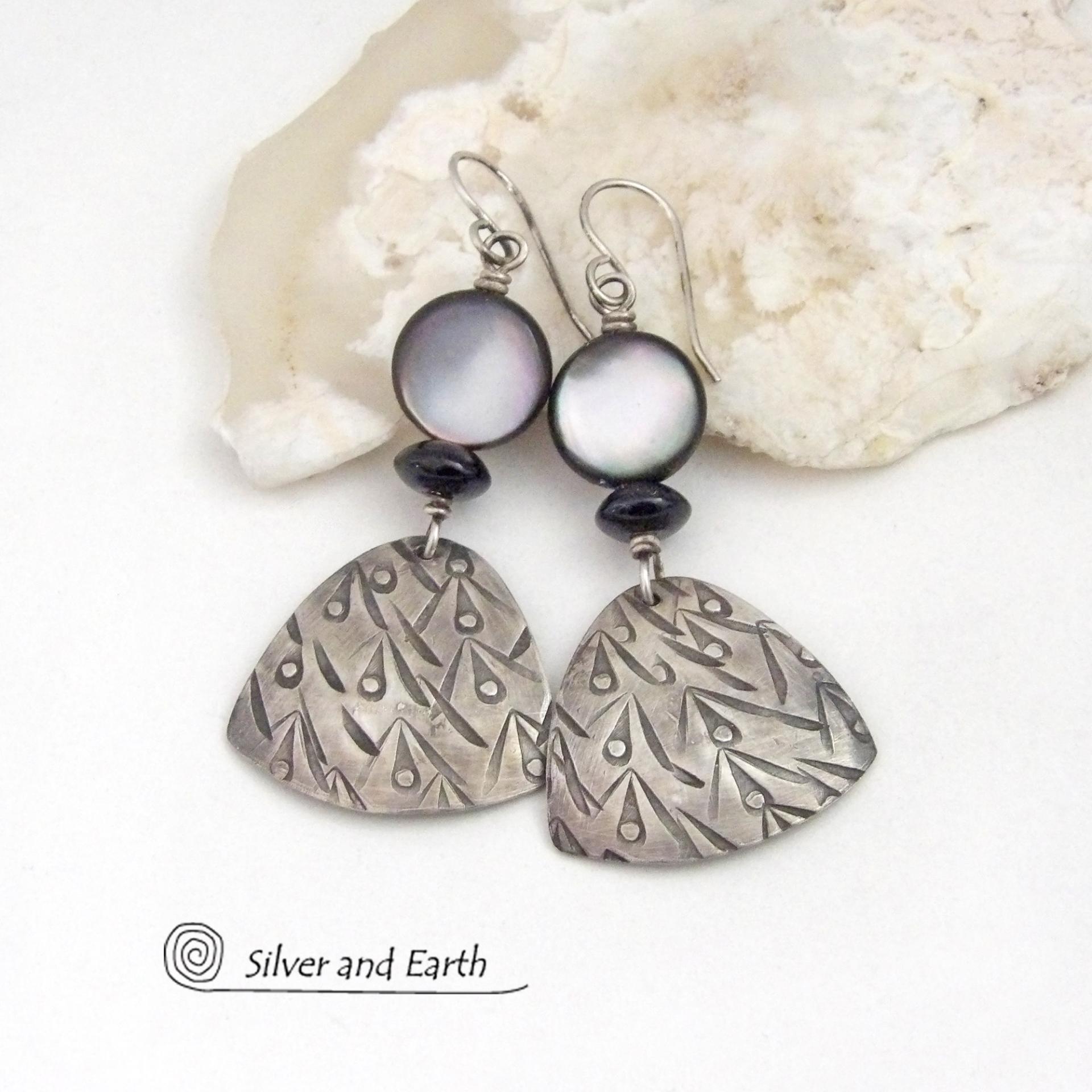 These handcrafted sterling silver earrings have a hand stamped texture and feature round black lip Mother-of-Pearl beads and tiny black onyx stones. The Mother of Pearl has a natural shimmery white hue with "rims" of black. They have a modern elegant chic style that will look great dressed up or down.