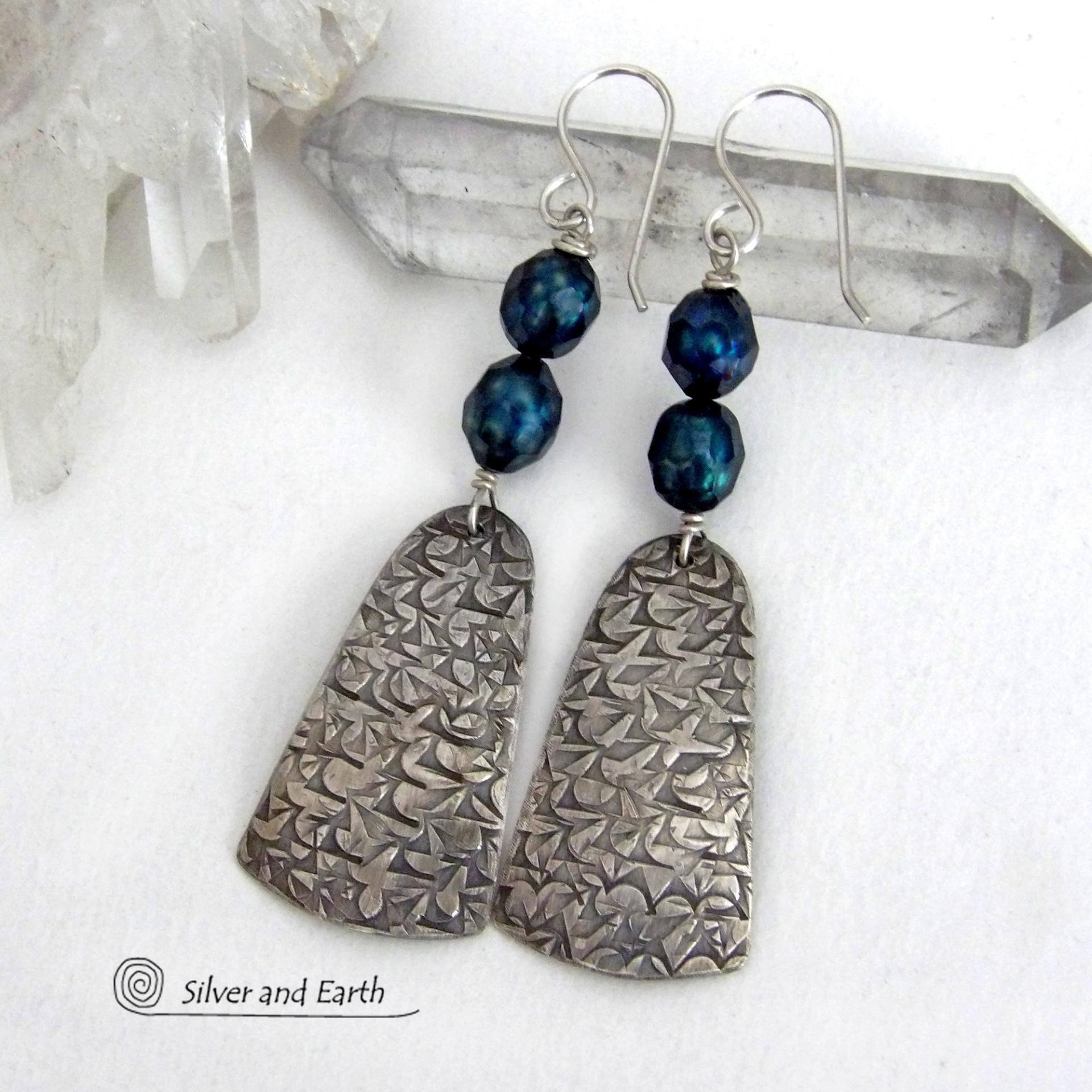 These sterling silver earrings feature handcrafted sterling silver dangles with an intricate hand stamped texture accented with deep teal blue freshwater pearls with a faceted finish.  They have a modern, elegant feel and will look great dressed up or down. They dangle from sterling silver ear wires. Handmade in the USA by Silver and Earth Jewelry. 