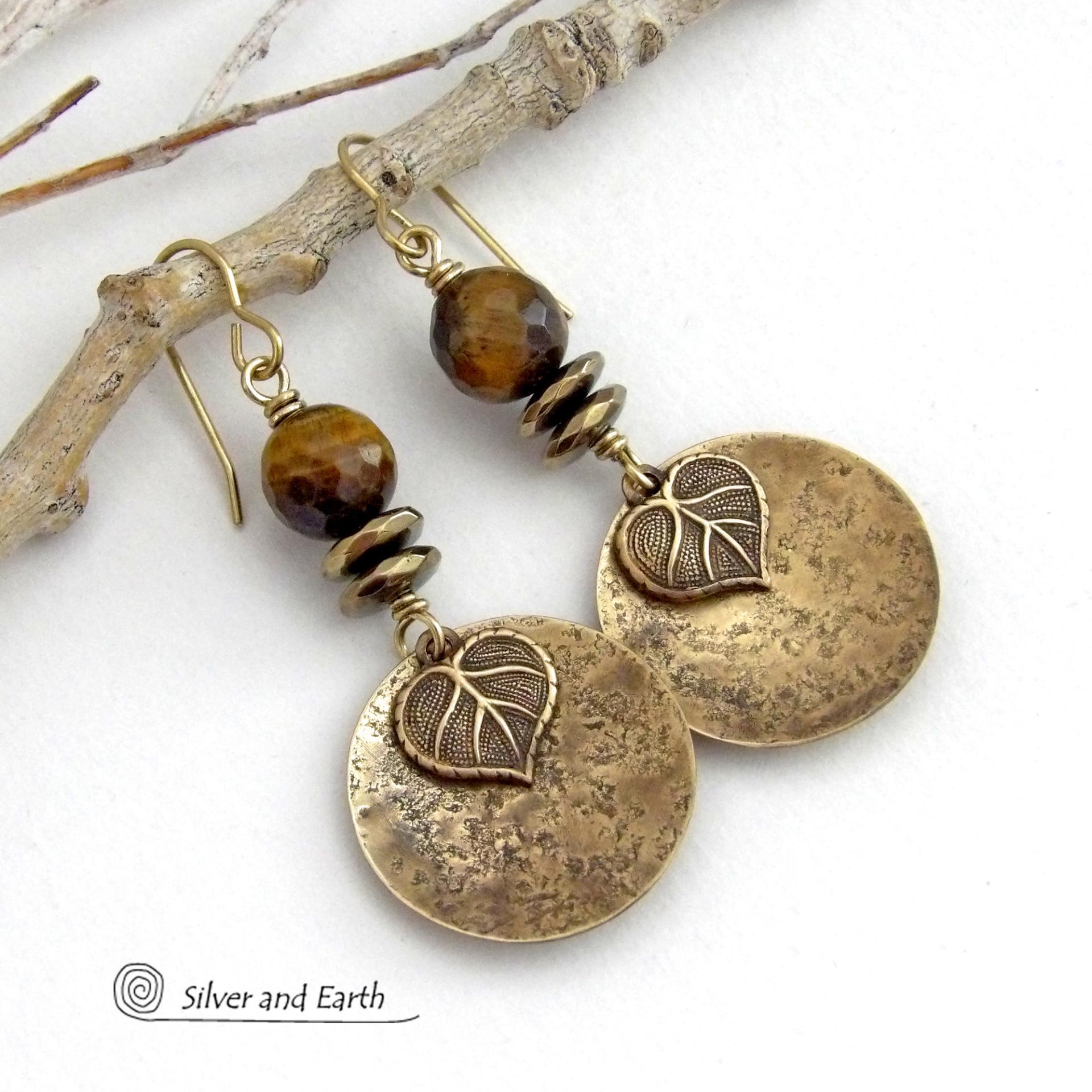 These handcrafted earrings feature gold brass dangles with a lightly hammered texture accented with natural tiger's eye gemstones, brass leaf charms and faceted hematite stones with a sparkly electroplated gold tone finish. The tiger's eye stones also have a faceted cut which casts off a beautiful natural sparkle and shine. They have a modern, elegant chic style that coordinates with all wardrobe styles. Makes a great gift for a nature lover - or a nice addition to your own jewelry wardrobe. 
