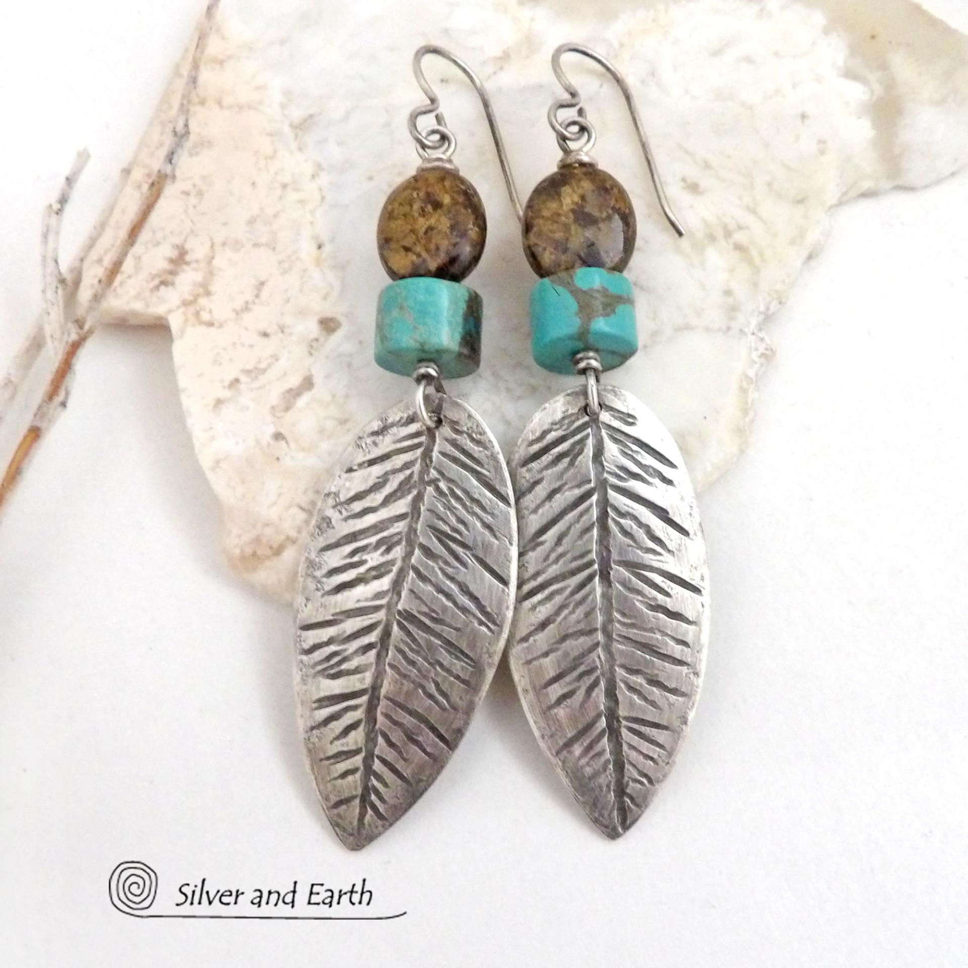 These handcrafted sterling silver feather earrings have a hand stamped texture and are accented with turquoise and bronzite stones which bring out the natural brown matrix in the turquoise stones. They have a native southwestern vibe that makes a bold statement. The earrings are handmade and are a beautiful example of southwest style jewelry. New Mexio True certified. 