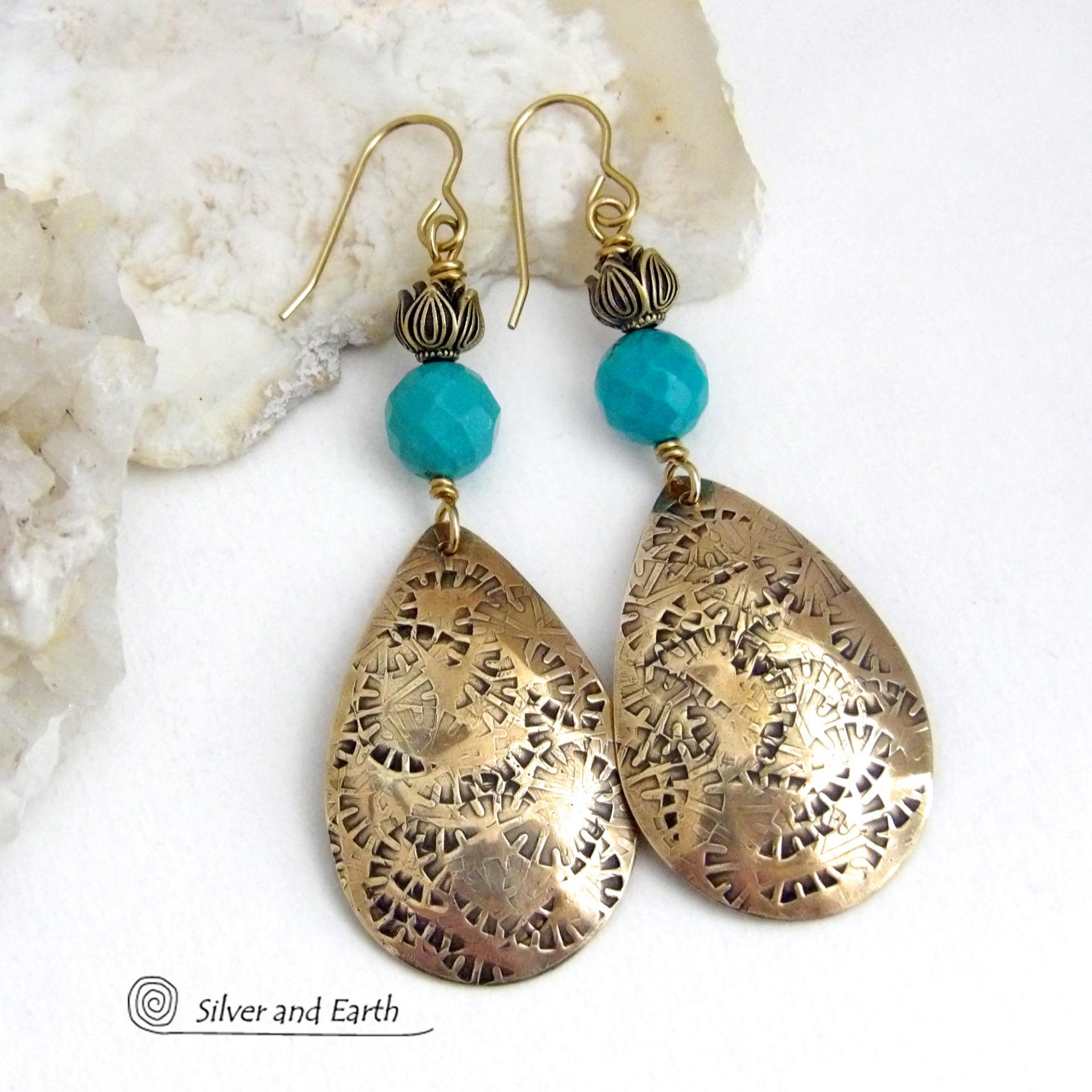 These handcrafted gold brass teardrop dangle earrings have a hand stamped texture accented with natural turquoise gemstones with a faceted finish and tulip flower-shaped brass beads. Big, long and striking - they have a modern elegant boho chic style that makes a bold statement. They'll coordinate beautifully with all wardrobe types - dressed up or down. Handmade in the USA by Silver and Earth Jewelry. 