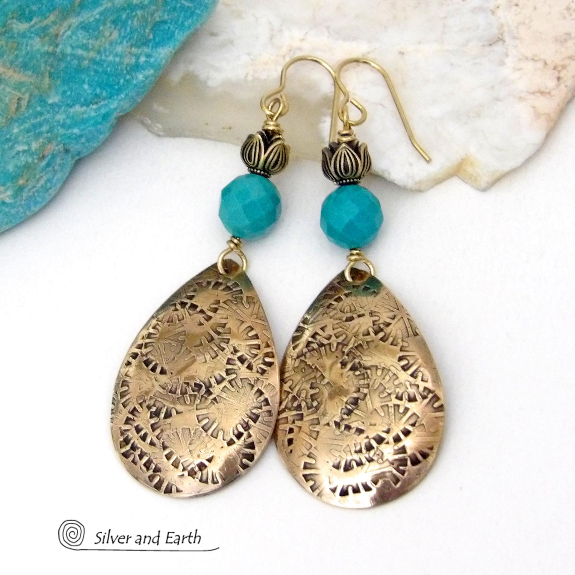 These handcrafted gold brass teardrop dangle earrings have a hand stamped texture accented with natural turquoise gemstones with a faceted finish and tulip flower-shaped brass beads. Big, long and striking - they have a modern elegant boho chic style that makes a bold statement. They'll coordinate beautifully with all wardrobe types - dressed up or down. Handmade in the USA by Silver and Earth Jewelry. 