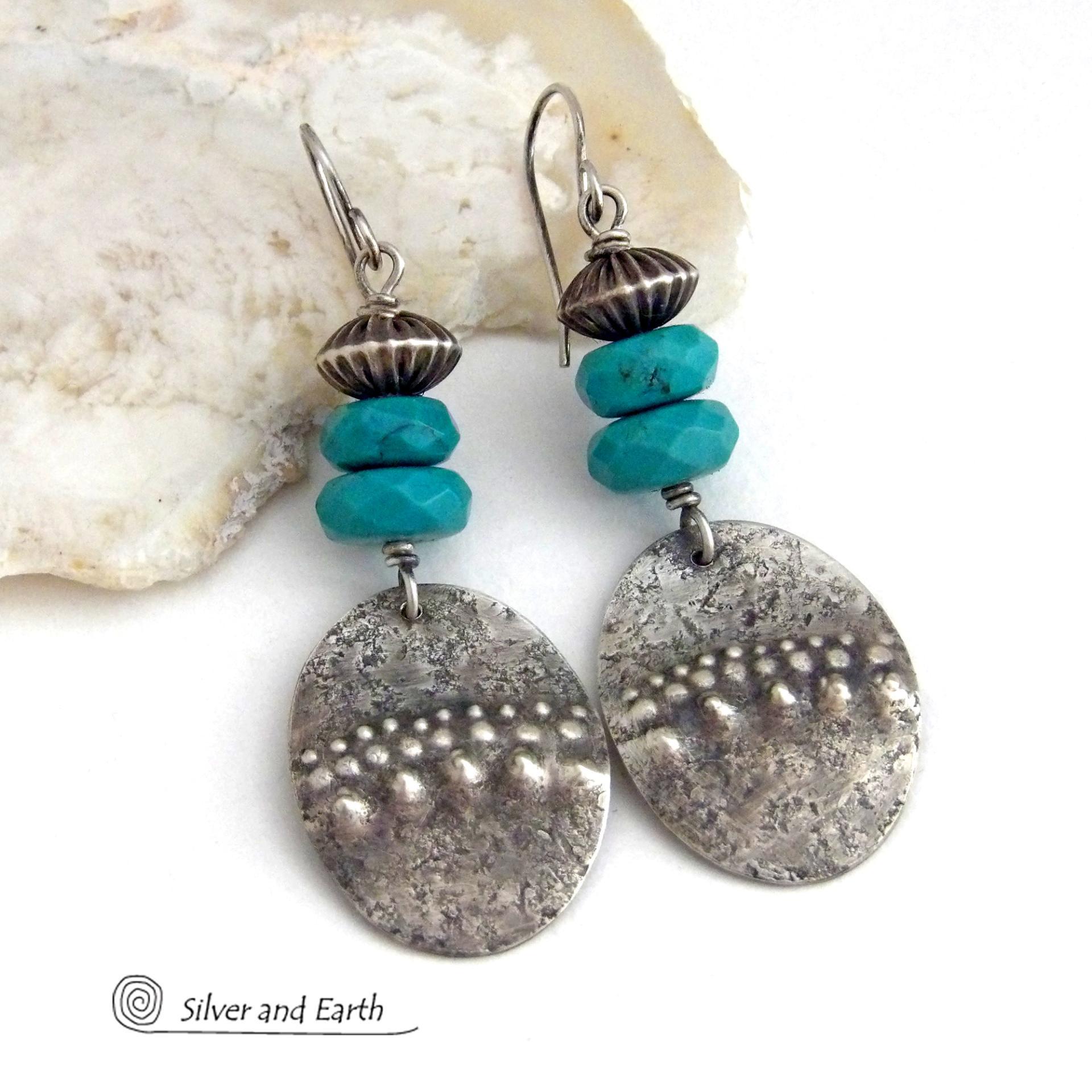 These handcrafted earrings feature sterling silver oval dangles with a hammered and hand stamped texture accented with faceted natural turquoise gemstones and oxidized sterling silver beads with a rich, corrugated texture and oxidized finish. They have a modern, southwestern style and are perfect for women that love to wear artisan handcrafted southwestern jewelry. Handmade in the USA by Silver and Earth jewelry, a New Mexico True Certified business. 