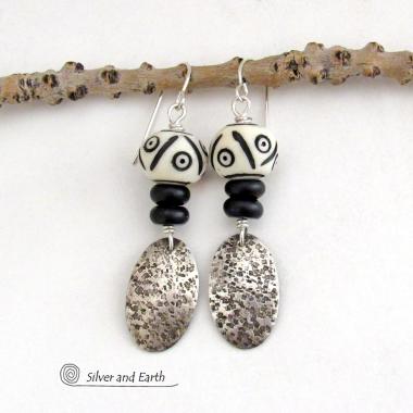 These handcrafted sterling silver earrings have a rustic, hand stamped texture and are accented with African carved bone and matte black agate beads. The bone beads have a bold, striking pattern of black circles and lines carved into a white base. Lightweight and fun to wear - they have an ethnic, tribal vibe and will make a unique statement.