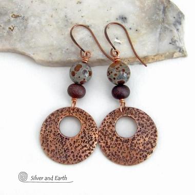 These handcrafted earrings feature round copper hoop dangles with a rustic hand stamped texture accented with natural spotted asteroid jasper and bronze glass beads. Unique and striking, they have an earthy organic flair that makes a bold statement. The jasper stones have a great natural spotted pattern with earthy shades of chocolate brown and grey. Your choice of ear wires - copper or hypoallergenic niobium.