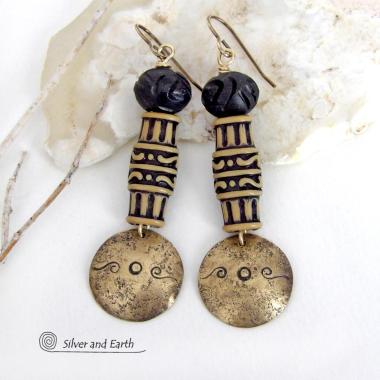 Bold and unique, these handcrafted earrings have an ethnic African tribal vibe. They feature gold brass dangles with a hand stamped and lightly hammered background texture accented with African beads with an intricately carved brownish-black and tan pattern topped off with black African carved bone beads. Unique and fun to wear - they'll make a bold, striking statement. Perfect for women that love to wear one-of-a-kind artisan handcrafted jewelry. Handmade in the USA by Silver and Earth Jewelry.