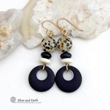 These handcrafted earrings feature matte black glass circle hoops accented with Dalmatian jasper gemstones, African bone and black glass beads. Unique and fun to wear, they have an earthy natural style with boho chic flair that makes a striking statement. They'll make a great gift for a natural stone lover - or a nice addition to your own jewelry wardrobe. Handmade in the USA by Silver and Earth Jewelry. 