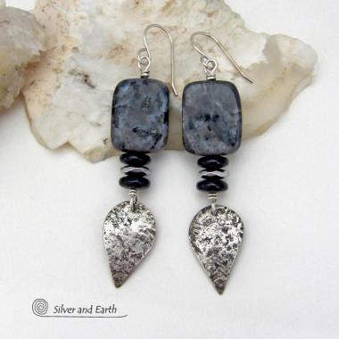 These handcrafted sterling silver earrings feature natural larvikite gemstones accented with small sterling silver dangles, black onyx and faceted silver hematite gemstones. The larvikite has a pearly, grayish black hue with iridescent flashes of light which cast off a natural shimmer & shine. They have a modern, chic contemporary style that will look great dressed up or down. Larvikite originates from the Larvik region in Norway. It's also called Norwegian moonstone and black labradorite. 
