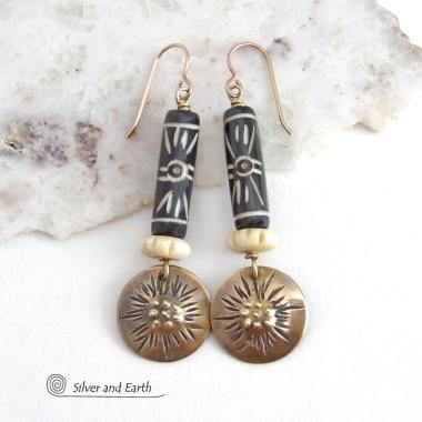 These handcrafted earrings feature African batik carved bone beads accented with textured gold brass dangles and carved bone beads. They have a boho chic tribal flair that will make a striking statement. Perfect for women that love to wear bold unique jewelry. Handmade in the USA by Silver and Earth Jewelry. 
