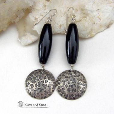These handcrafted sterling silver dangle earrings have a hand stamped texture and oxidized finish and feature long black onyx gemstones. The stones are cut into a unique, elongated tubular shape and have a rich black hue and high polish. They have a modern, contemporary style that will look great with all wardrobe types. Handmade in the USA by Silver and Earth Jewelry.