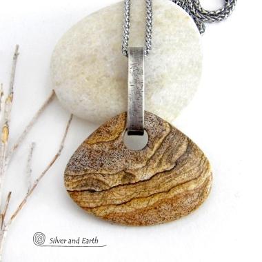 This handcrafted necklace features a large, chunky natural picture jasper stone accented with a handcrafted sterling silver bail. The stone has a beautiful natural pattern in various shades of brown, beige and gray. Big and bold, this necklace is a real one-of-a-kind statement piece - perfect for anyone that loves natural stones! It's reversible and can be worn on either side. Coordinating earrings sold separately. Handmade in the USA by Silver and Earth Jewelry.