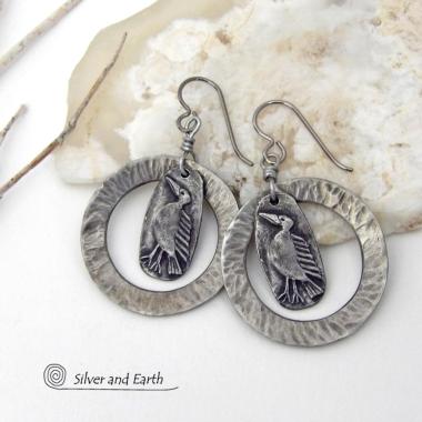 These handcrafted earrings feature silver pewter circle hoops with a hammered texture accented with silver pewter bird charms dangling in front. Lightweight and comfortable to wear, they have a casual earthy style with rustic flair that coordinates with all wardrobe types. They'll make a great gift for a nature / bird lover - or a unique addition to your own jewelry wardrobe. Handmade in the USA by Silver and Earth Jewelry.