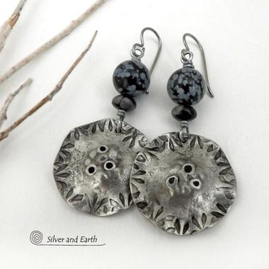 Handcrafted earrings with a modern bold edgy vibe. They feature rustic hammered and hand stamped silver tone pewter dangles accented with natural snowflake obsidian gemstones. The stones have a natural pattern in hues of black and soft gray. This stone is a natural volcanic glass which contains the mineral cristobalite - which creates the "snowflake" type patterns. Bold and striking - they're sure to make a statement. Earrings l