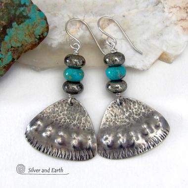 These handcrafted sterling silver earrings feature a unique hand textured design and are accented with natural turquoise and metallic gray pyrite stones. They have a southwestern boho tribal flair and will make a striking statement. The pyrite stones add a touch of natural sparkle and shine. Handmade in the USA by Silver and Earth Jewelry. 